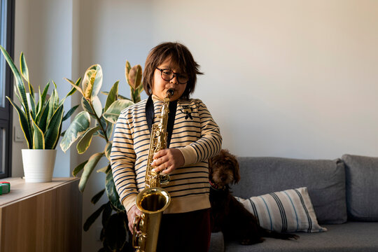 kid playing saxophone at home