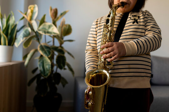 kid playing saxophone at home