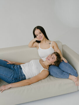 Middle age woman with short hairstyle and Young dwarf woman sitting on sofa