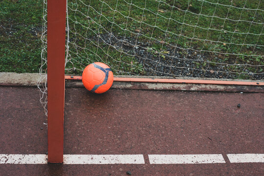 Football ball in goalpost in field