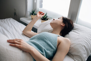 Tranquil woman lying in bed in morning
