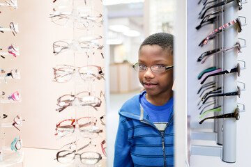 Boy admire reflection as he tries on glasses