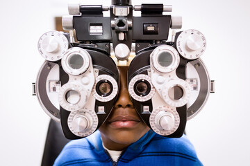 Boy looks at camera through phoropter