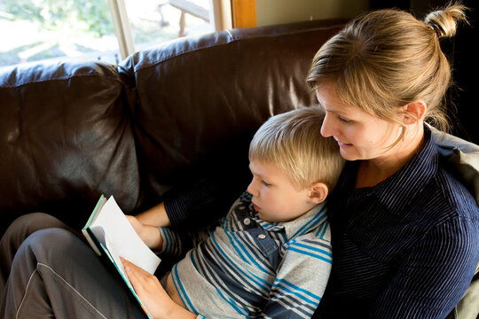 Mother and son read on couch