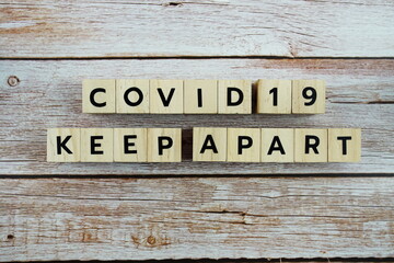 Covid-19 Keep Apart word alphabet letters on wooden background