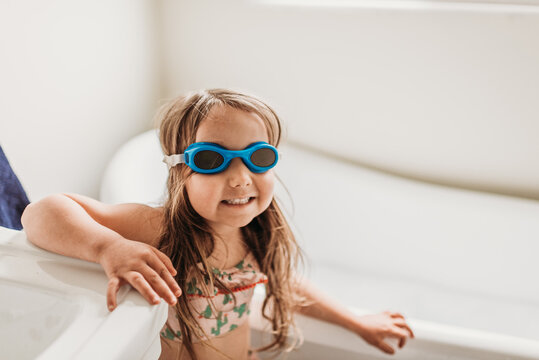 Girl with goggles standing in bathroom