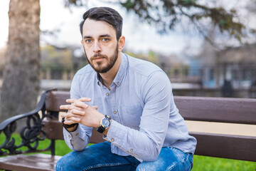 Obraz premium Portrait of a man who sits on a bench and thinks