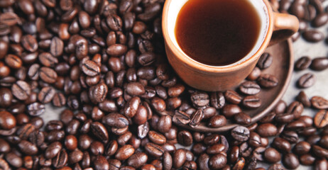  Clay cup of coffee on coffee beans.