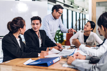 Group of professional asian business meeting and discussing strategy with new startup project.Creative business people planning and brainstorm with laptop computer in modern office.Teamwork concept