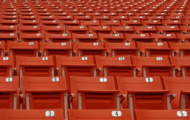 Naklejka premium The seat to watch football has a number that has no people,red chair on football field