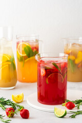 Jugs of fresh refreshing fruit drinks with fruit wedges, summer cold juices with ice