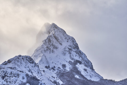 Severe landscape with snowy rocky mountain peak