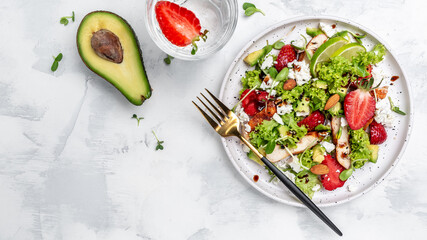 Healthy meal of strawberry avocado salad with eta cheese, lettuce and nuts balsamic vinegar, clean eating for weight loss. Long banner format. top view - obrazy, fototapety, plakaty