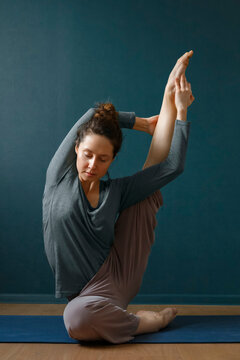 Young woman stretching leg in Heron pose variation