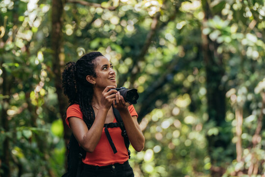 Woman Using Camera in Tropical Forest