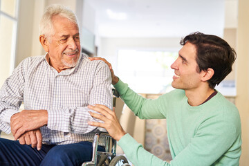 Fürsorglicher Mann kümmert sich um Senior Vater im Rollstuhl