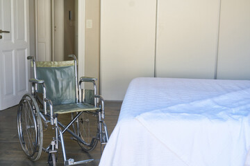 Leerer Rollstuhl und leeres Bett im Krankenhaus