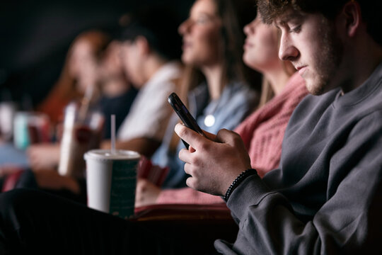 Movies: Male Teen Uses Cell Phone During Movie