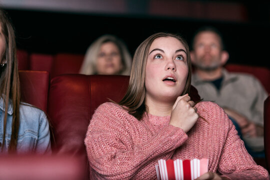 Movies: Female Teen Watching A Scary Movie In Theater