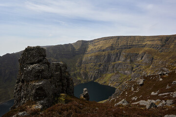 view of a lake between large rocks of a mountainous valley. Comeragh Mountains, Waterford, Ireland