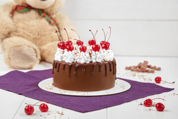 Chocolate sponge cake with whipped cream and maraschino cherries