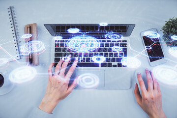 Double exposure of woman hands working on computer and social network theme hologram drawing. Top View. People connection concept.