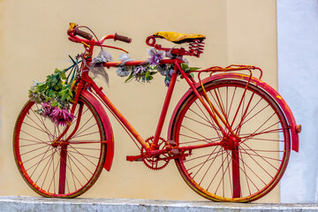 Fototapeta na wymiar Old rusty red bike with flowers, Sintra, Portugal