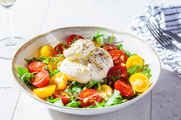 Burrata cheese salad with arugula and tomatoes.