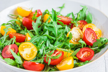 Arugula and tomatoes salad. Healthy vegan food concept.