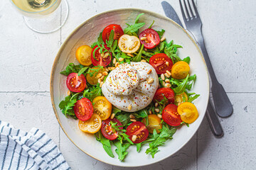 Burrata cheese salad with arugula and tomatoes.