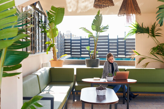 Businesswoman talking on her phone at cafe table