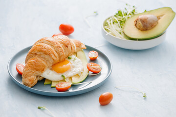 stuffed croissant with avocado, omelet egg and fresh vegetable