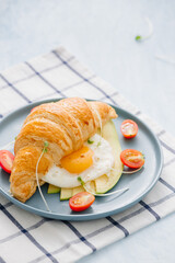 stuffed croissant with avocado, omelet egg and fresh vegetable