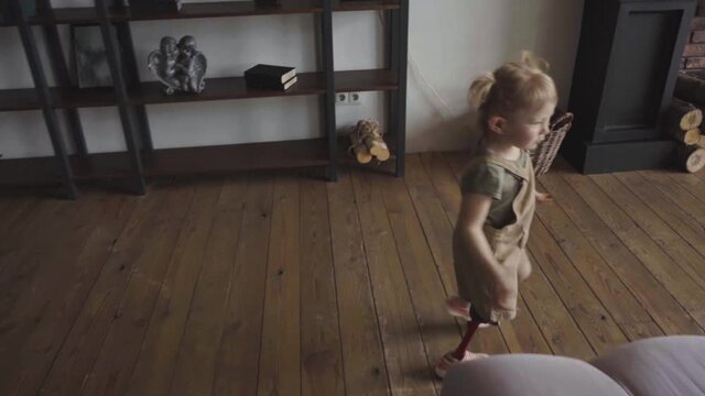 girl with leg prosthesis walking in living room