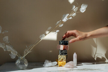 Woman taking natural soap from table in bathroom