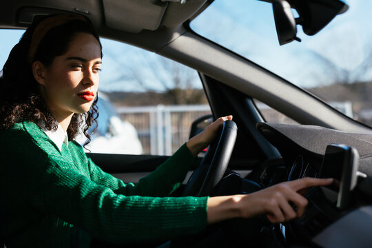Young woman using GPS navigator in car