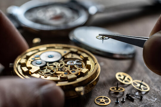 Watch repair process. Craftsman instaling new parts into wristwatch
