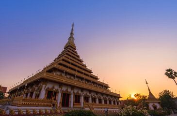 golden ancient pagoda of Phra Mahathat Kaen Nakhon (Wat Nong Wang) temple with twilight sunset sky, Thai traditional religious history travel attraction in Khon Kaen, Thailand