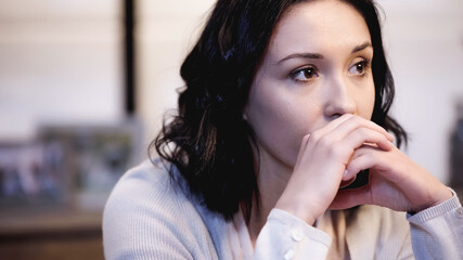 Fototapeta na wymiar tired woman covering mouth with clenched hands at home