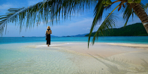 woman walking on white sand beach in the  andaman sea 