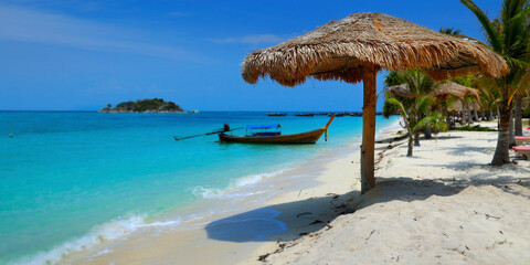 long tail boat, in white sand beach in the andaman sea