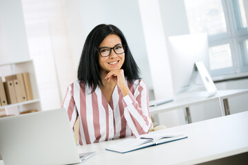 Portrait of a business woman with glasses at workplace in office