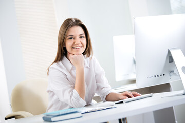 Portrait of business woman looking at camera at workplace in an office