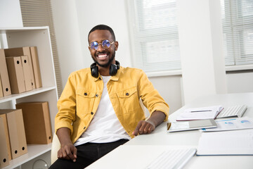 Happy african american businessman smiling at camera in office