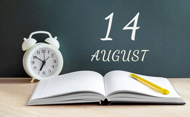august 14. 14-th day of the month, calendar date.A white alarm clock, an open notebook with blank pages, and a yellow pencil lie on the table.Summer month, day of the year concept
