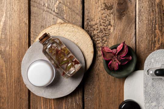 Aromatic oil with herbs in transparent bottles on wooden background