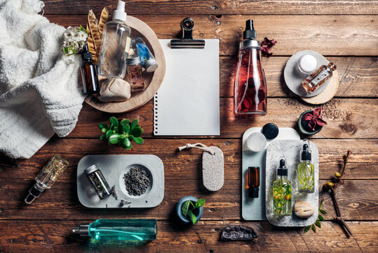 SPA accessories with oils and blank paper on wooden surface