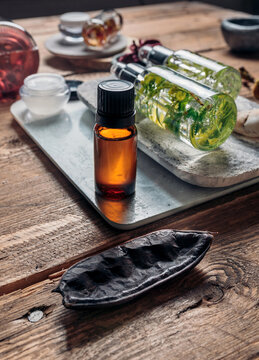Aromatic oils with herbs in transparent bottles on wooden background