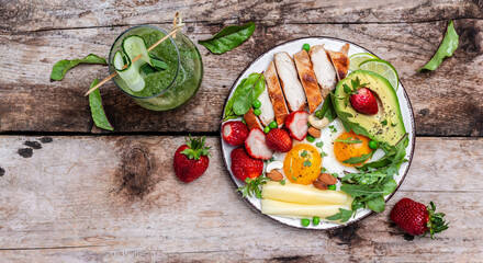 Low carb high fat breakfast, Grilled chicken fillet and avocado, fried eggs with strawberry, cheese and nuts. Detox smoothie, fresh green, Ketogenic diet. Healthy food concept, top view