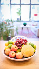 A bowl of fruit sits on a table in an apartment.